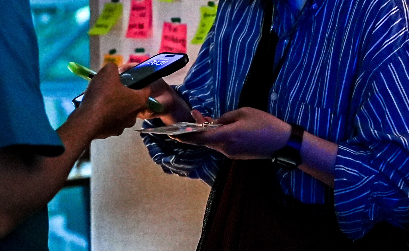 写真：NFCカードにスマートフォンをかざしている、手元だけの様子。